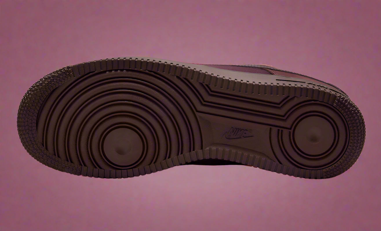 Brown sole of a shoe with visible Nike logo on a white background
